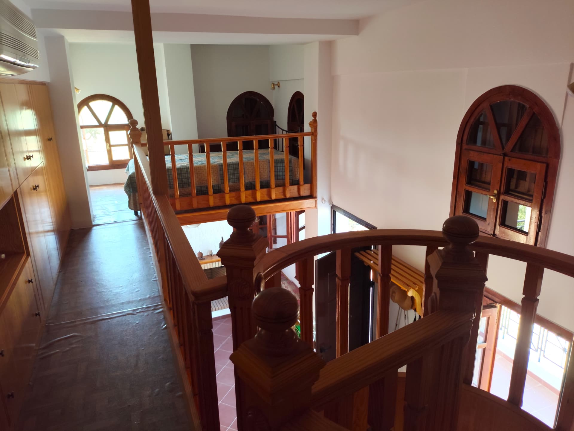 Mezzanine sleeping level with arched wooden windows