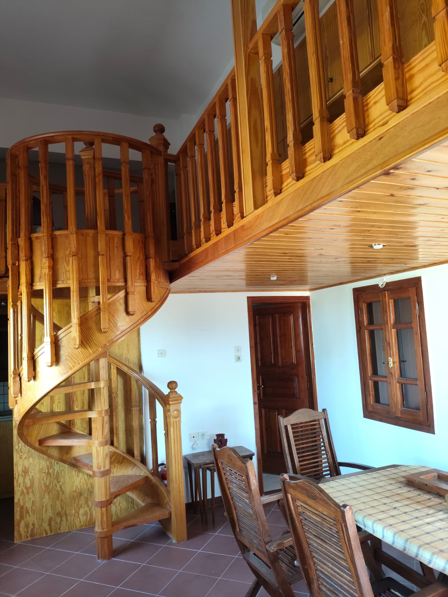 Carved spiral wooden staircase rising to the mezzanine level